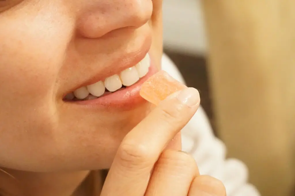 Woman eating a gummy.