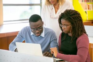 Two students in front of a laptop