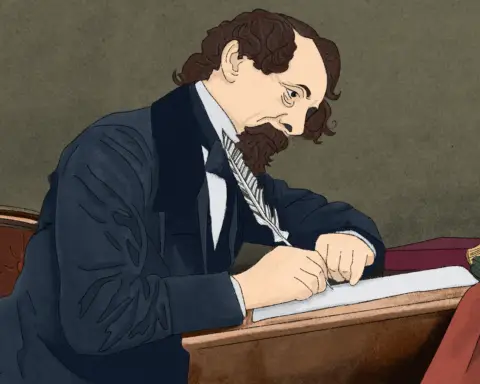 A balding man with brown hair and beard in a black seat sits in a brown chair at a desk in front of grey-green background. He is writing intently on a crisp sheet of paper, quill in hand, inkwell before him, maroon book to his side, as be brings his story to life.